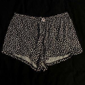 Black shorts with small white hearts on them with a little pink bow